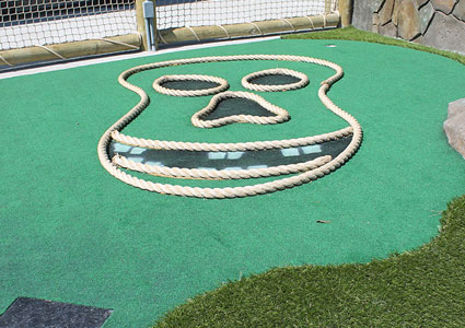 flat pirate skull outline made of rope on Putt Putt course green