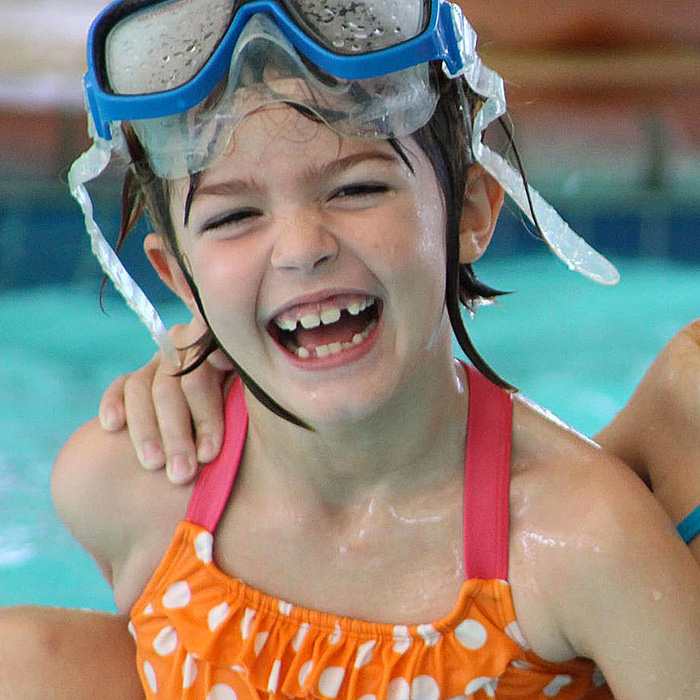 girl with snorkel masks laughing in pool