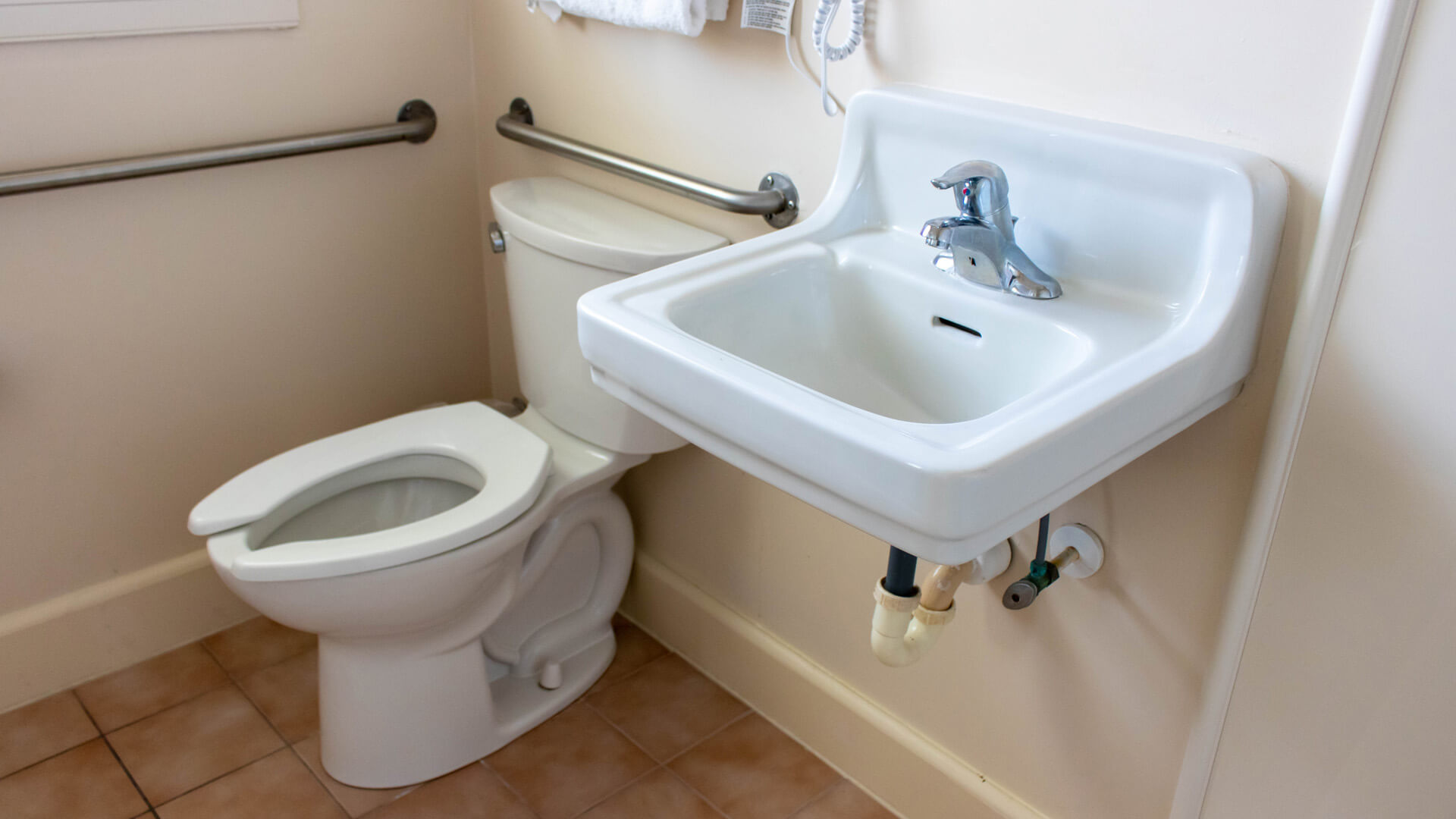 Ranch Style bathroom with toilet grab bars and sink